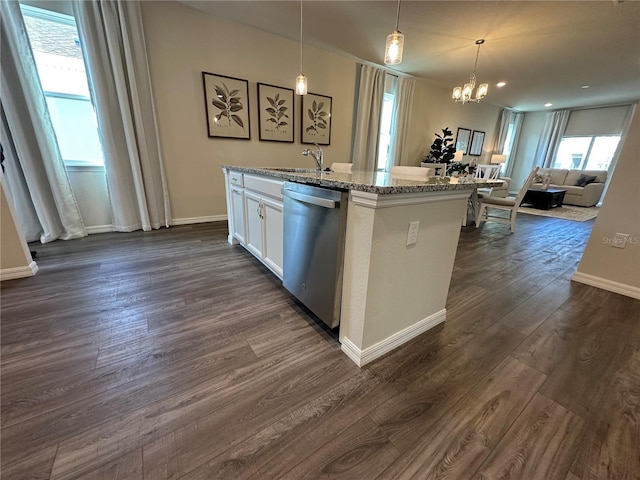 kitchen with decorative light fixtures, stainless steel dishwasher, light stone countertops, dark wood-type flooring, and a center island with sink