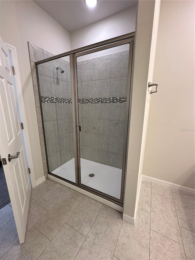 bathroom with tile patterned flooring and a shower with shower door