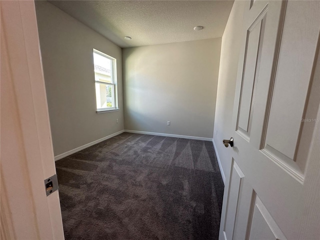 carpeted empty room with a textured ceiling