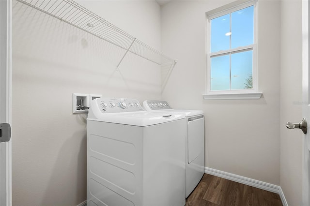 washroom featuring dark wood finished floors, baseboards, washing machine and dryer, and laundry area