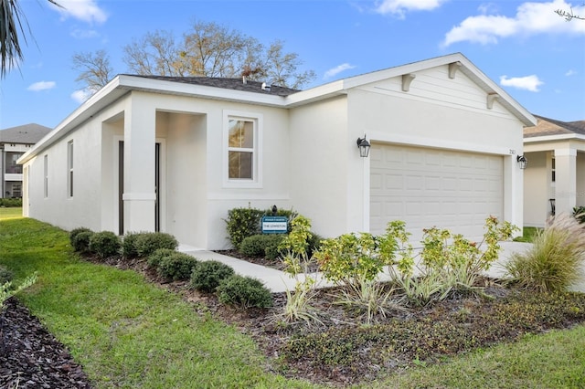 view of front of house with an attached garage, a front yard, and stucco siding