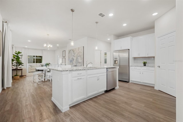 kitchen featuring visible vents, a center island with sink, appliances with stainless steel finishes, and light wood-type flooring