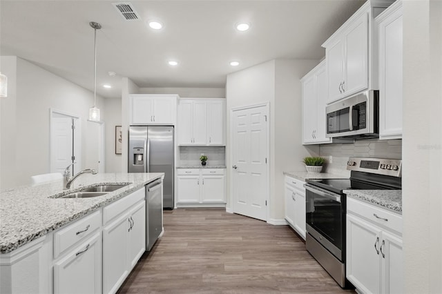 kitchen with visible vents, light wood-style flooring, a sink, stainless steel appliances, and white cabinets