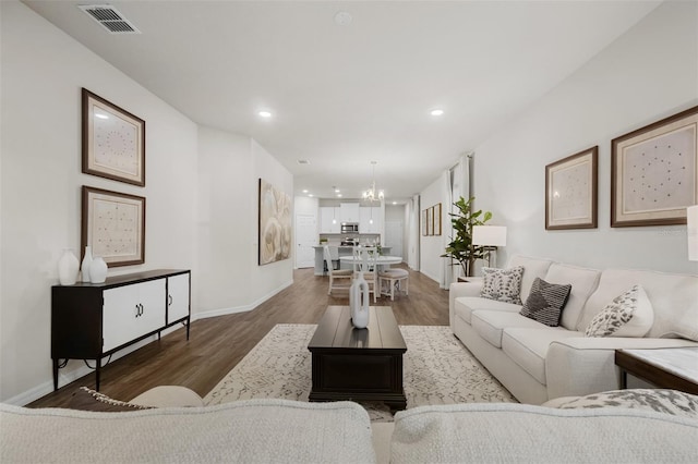 living area with dark wood finished floors, an inviting chandelier, recessed lighting, and visible vents