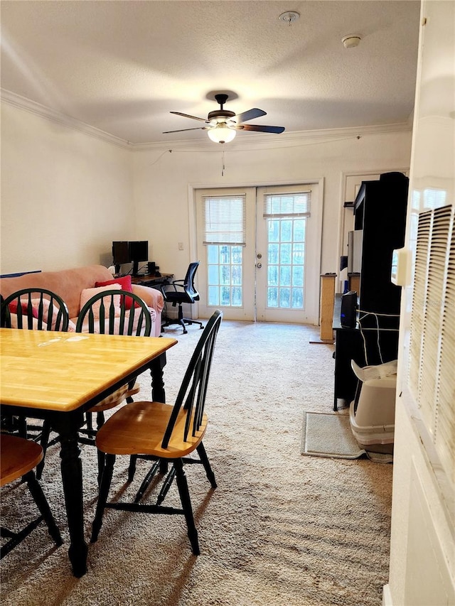 dining area with a textured ceiling, french doors, crown molding, and light colored carpet