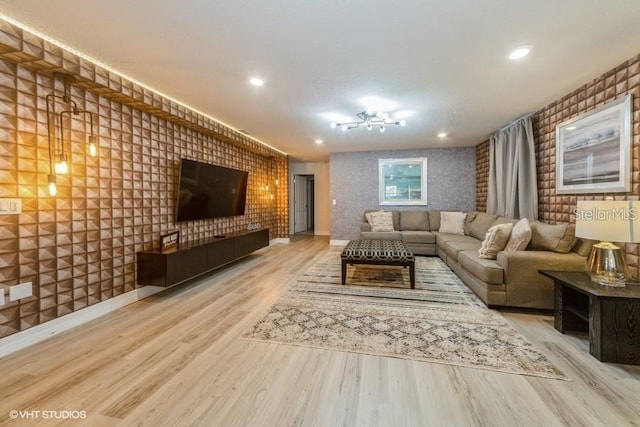 living room with brick wall and light hardwood / wood-style flooring