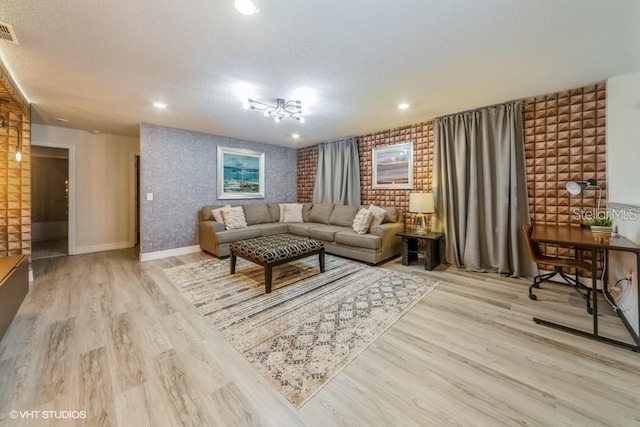 living room with light hardwood / wood-style flooring and a textured ceiling