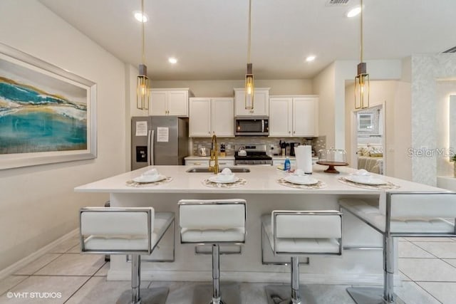 kitchen with sink, decorative light fixtures, a breakfast bar area, and stainless steel appliances