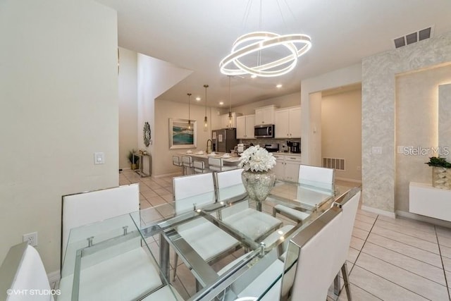 tiled dining space with sink and a chandelier