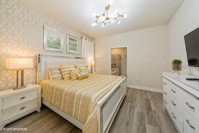 bedroom with hardwood / wood-style flooring, ensuite bathroom, and an inviting chandelier