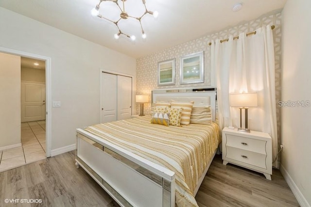 bedroom with an inviting chandelier, hardwood / wood-style flooring, and a closet