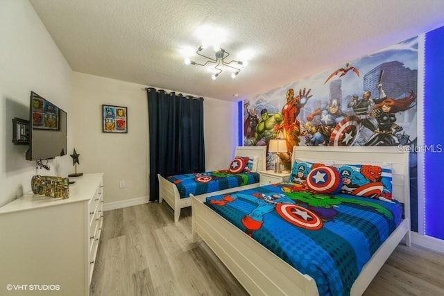 bedroom with a textured ceiling and light wood-type flooring