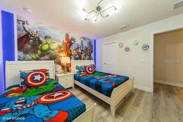 bedroom with light hardwood / wood-style flooring and a textured ceiling