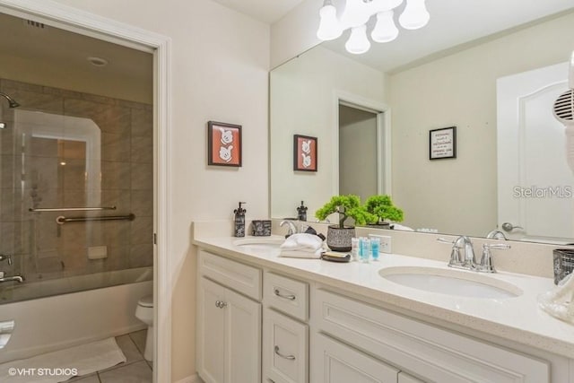 full bathroom featuring tile patterned flooring, tiled shower / bath combo, vanity, toilet, and a chandelier