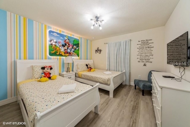 bedroom featuring light hardwood / wood-style flooring and a textured ceiling