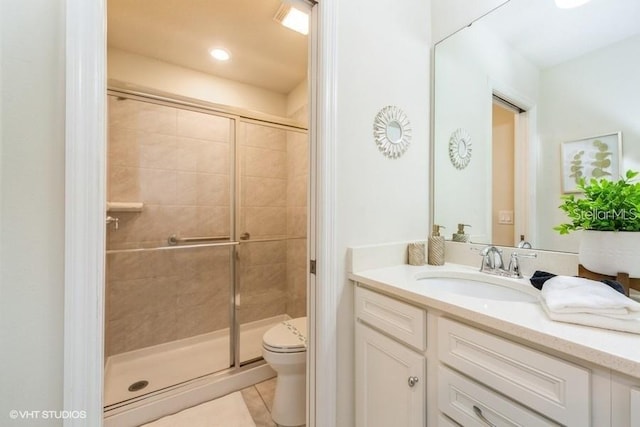 bathroom with vanity, toilet, a shower with shower door, and tile patterned flooring