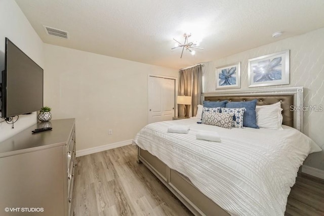 bedroom with light hardwood / wood-style flooring, a closet, and a textured ceiling