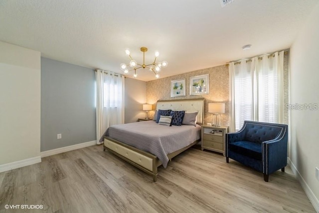 bedroom featuring an inviting chandelier and light hardwood / wood-style floors