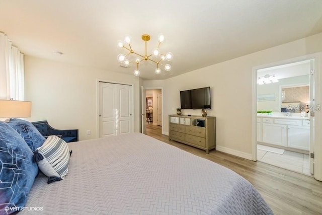 bedroom featuring a notable chandelier, ensuite bathroom, a closet, and light wood-type flooring