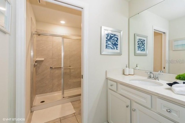 bathroom featuring tile patterned flooring, vanity, and walk in shower