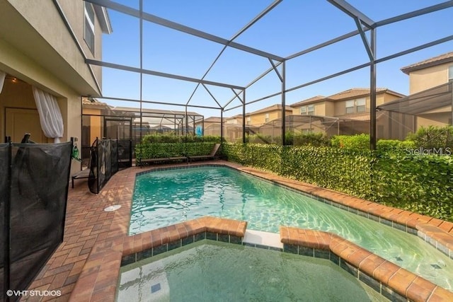 view of swimming pool with an in ground hot tub and a lanai