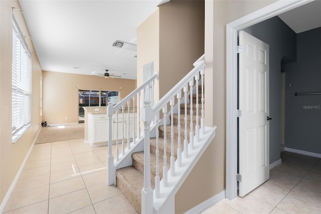 staircase featuring tile patterned flooring and ceiling fan