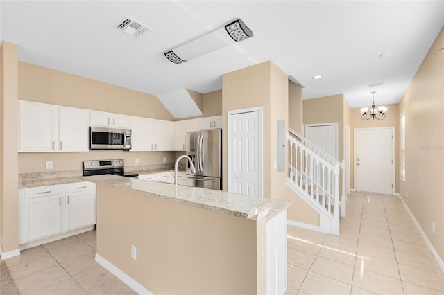 kitchen featuring light stone countertops, stainless steel appliances, an island with sink, and white cabinets