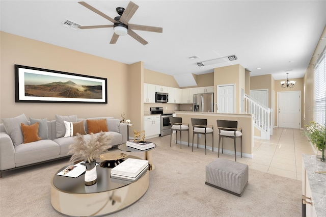 carpeted living room featuring ceiling fan with notable chandelier