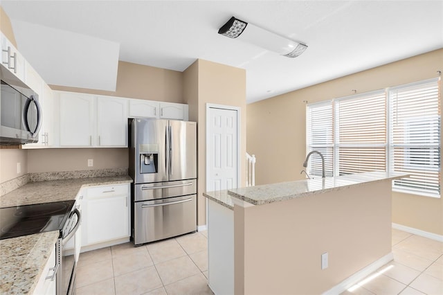 kitchen featuring light stone countertops, appliances with stainless steel finishes, a kitchen island with sink, and white cabinets