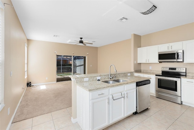 kitchen featuring appliances with stainless steel finishes, sink, a center island with sink, and white cabinets