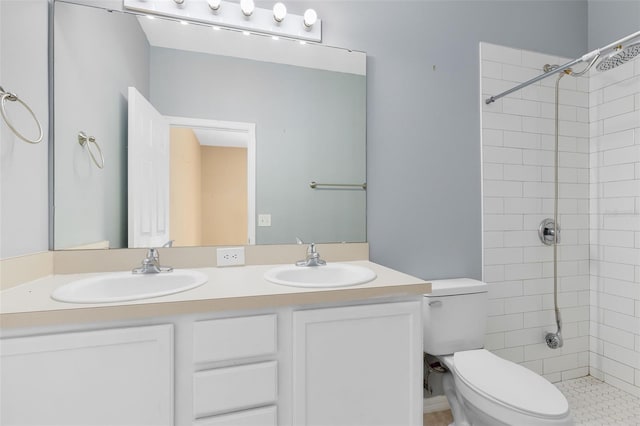 bathroom featuring tiled shower, vanity, and toilet