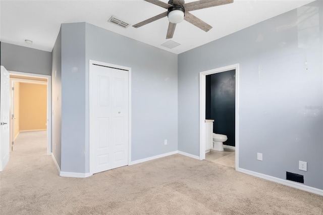 unfurnished bedroom with ensuite bathroom, light colored carpet, ceiling fan, and a closet