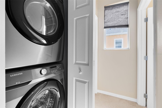 laundry area with light carpet and stacked washing maching and dryer