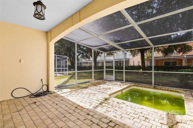 view of swimming pool with a hot tub, a patio, and glass enclosure