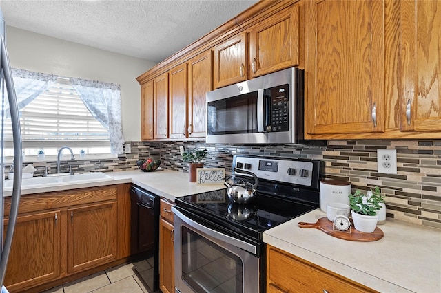 kitchen with sink, backsplash, stainless steel appliances, and light tile patterned flooring