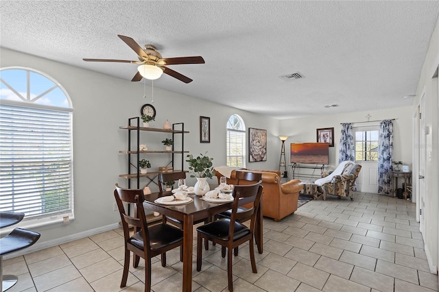 dining room with light tile patterned floors, a textured ceiling, and ceiling fan