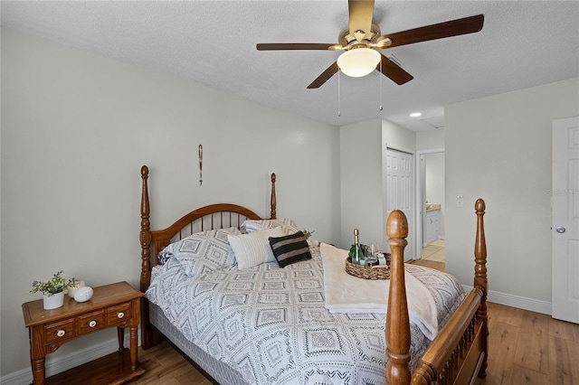 bedroom featuring ceiling fan, connected bathroom, a textured ceiling, and light wood-type flooring