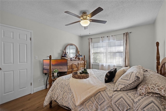 bedroom featuring ceiling fan, wood-type flooring, and a textured ceiling