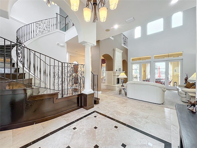 interior space featuring ornate columns, a notable chandelier, and french doors