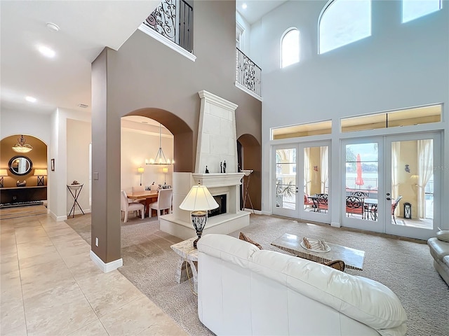 living room featuring light carpet, a towering ceiling, and french doors