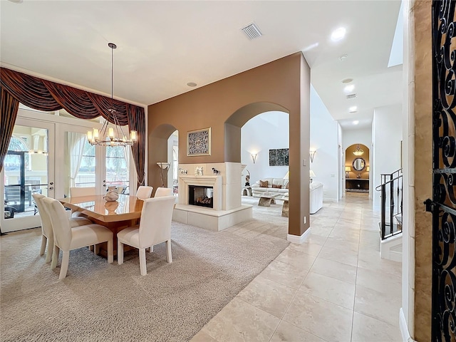 dining area featuring french doors, light colored carpet, and a notable chandelier