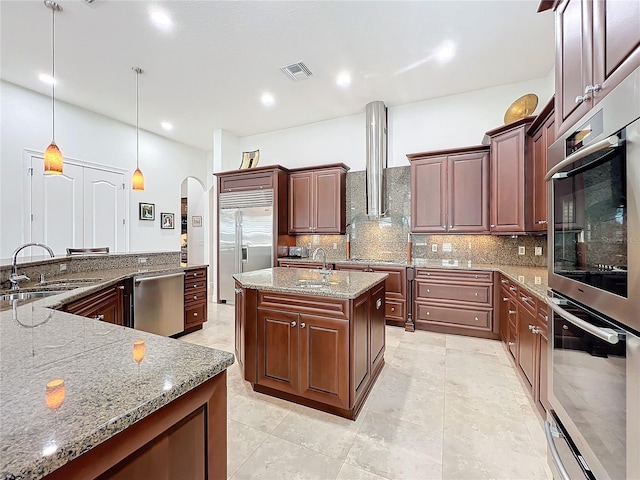 kitchen featuring stainless steel appliances, light stone countertops, sink, and pendant lighting