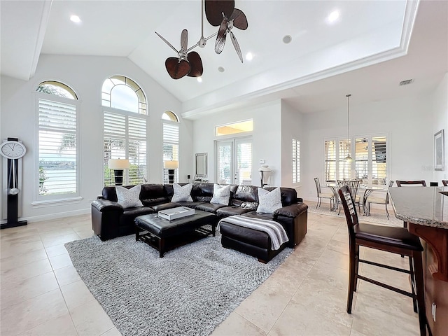 tiled living room with french doors, ceiling fan, and a towering ceiling