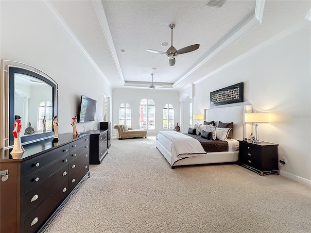 bedroom featuring ceiling fan, ornamental molding, a textured ceiling, light carpet, and a raised ceiling