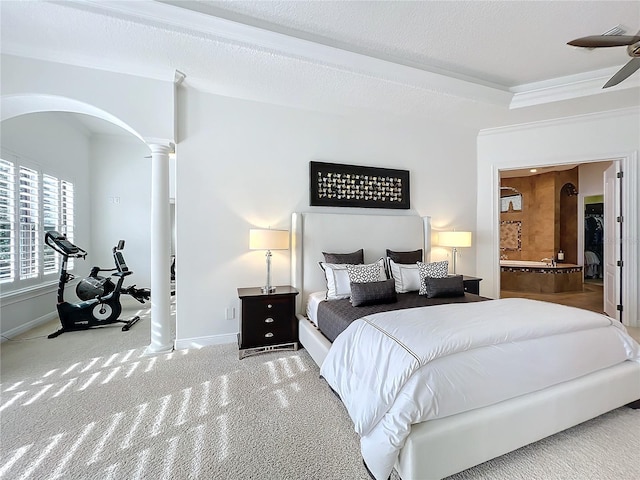 bedroom with ceiling fan, ensuite bath, carpet flooring, and ornate columns