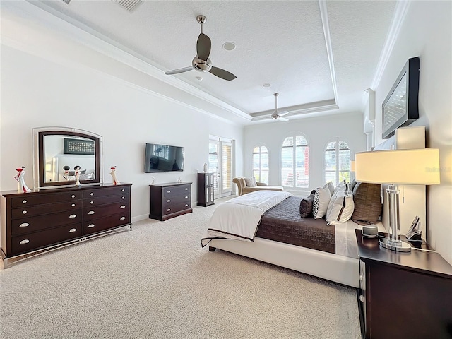 carpeted bedroom with a raised ceiling, ornamental molding, a textured ceiling, and ceiling fan