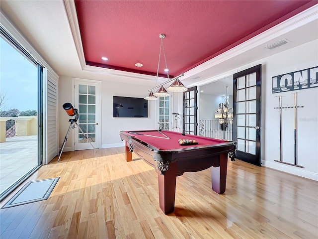 game room with french doors, billiards, a tray ceiling, and light wood-type flooring