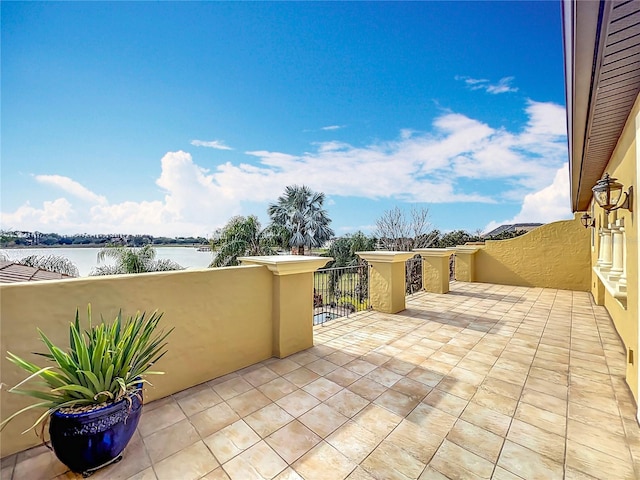 view of patio with a balcony and a water view