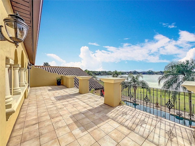 view of patio / terrace with a balcony and a water view