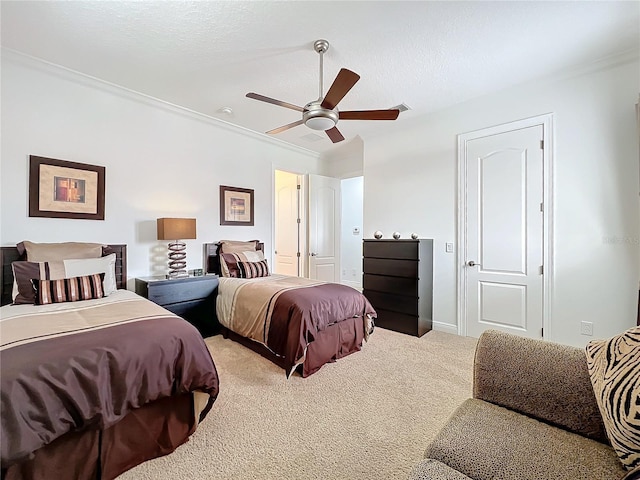 carpeted bedroom with ornamental molding and ceiling fan